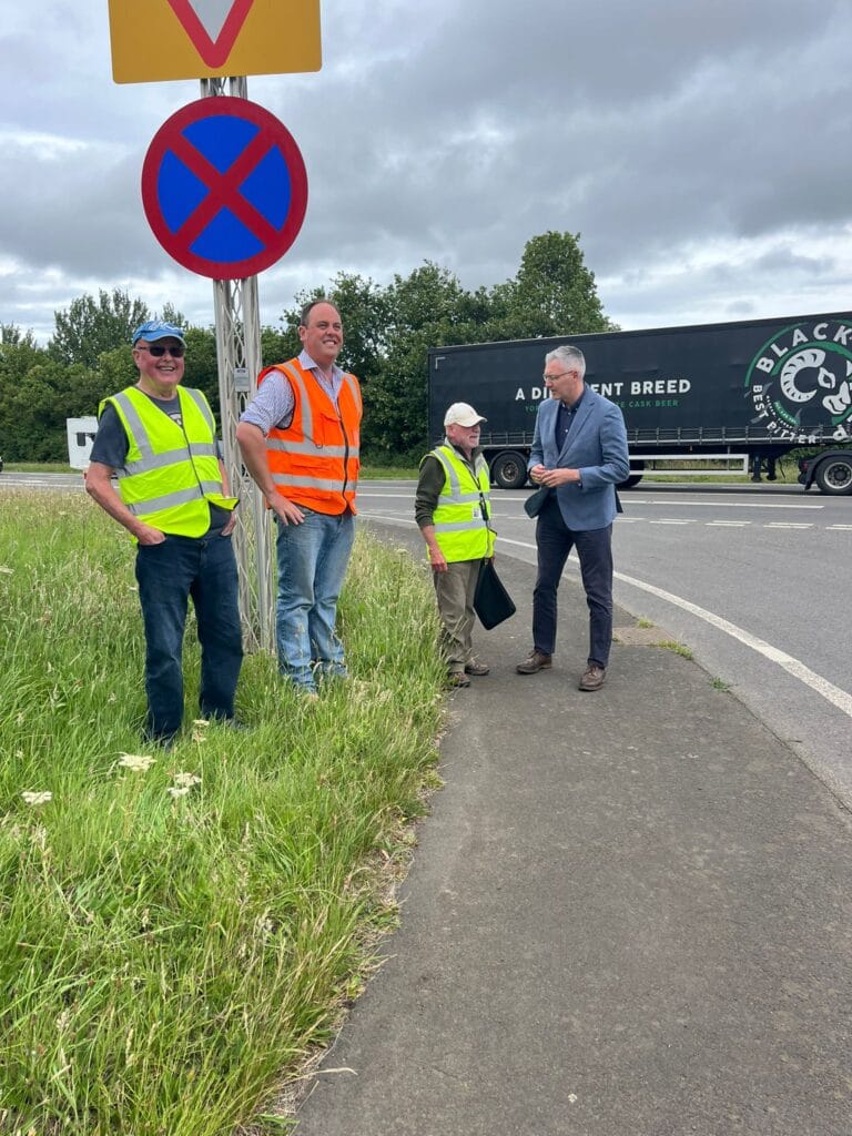 David speaking with residents next to a busy A1 junction 